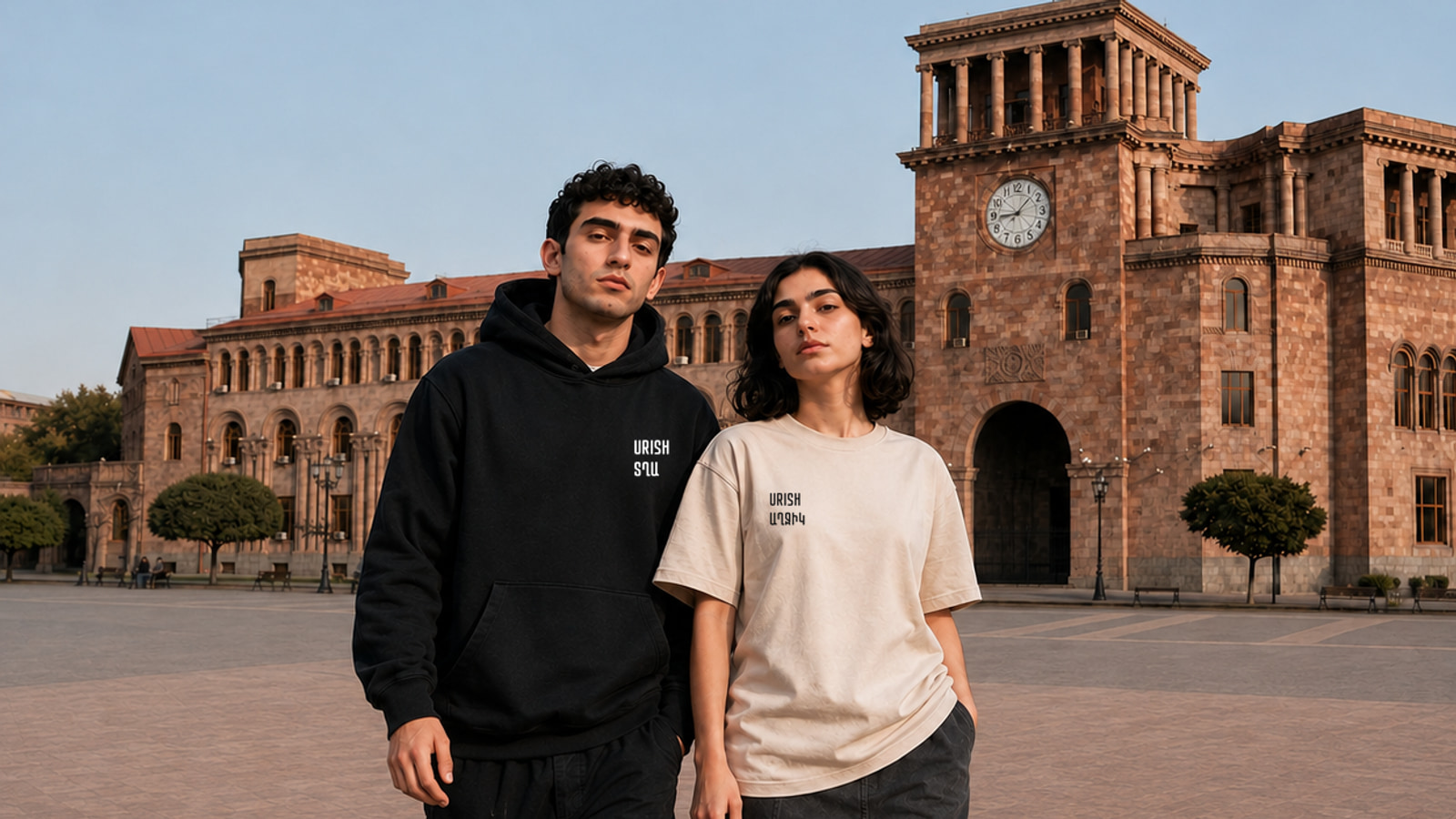 Two models in Republic Square wearing a black URISH hoodie and a beige URISH T-shirt