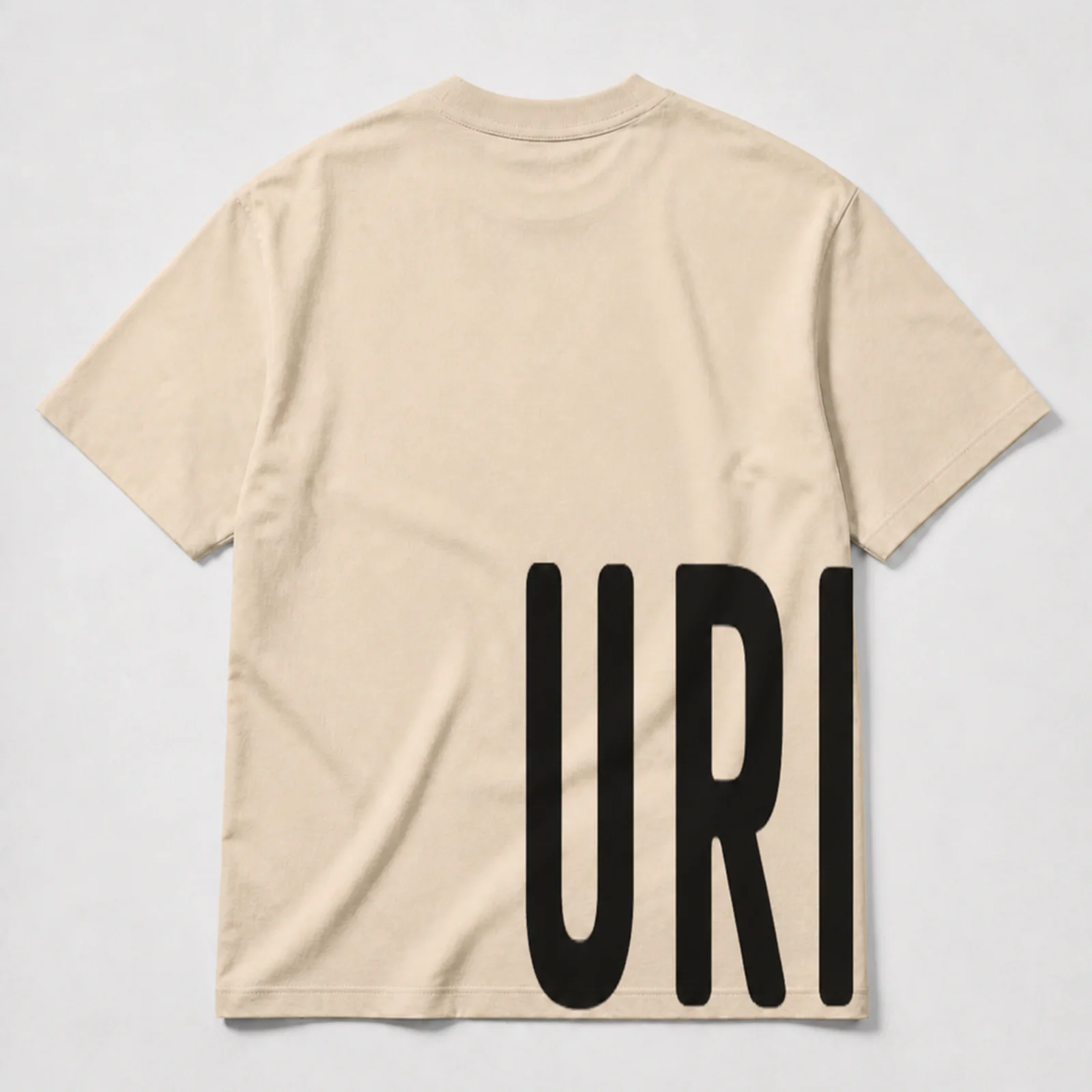 Back view of the URISH Wrap beige T-shirt with black “URISH” lettering running from the back to the front